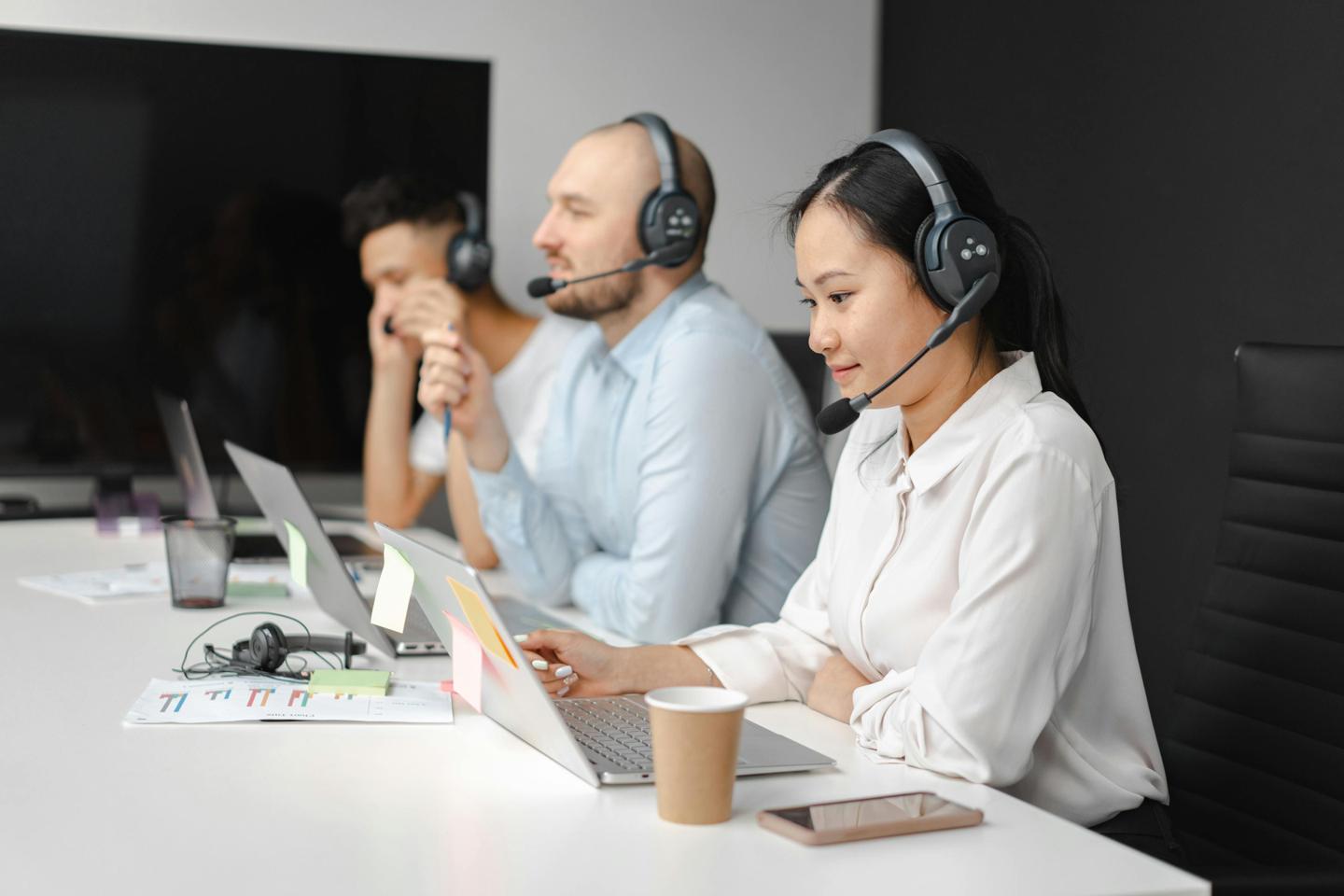 Équipe travaillant dans un centre d'appel moderne avec casques