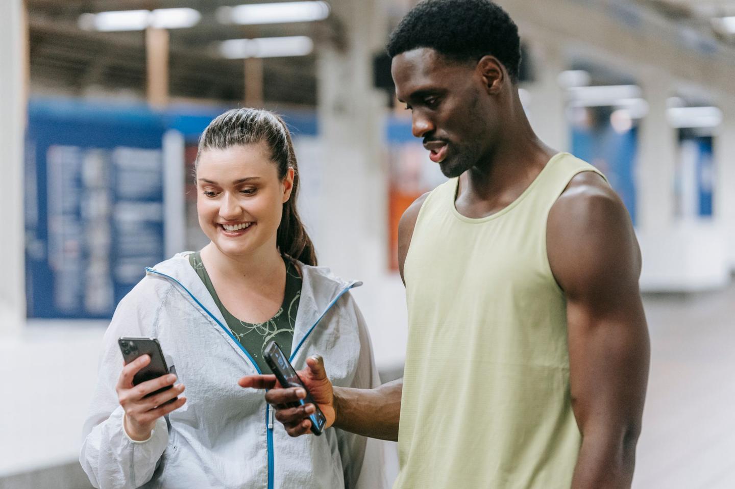 Deux jeunes en tenue de sport consultant une application sur smartphone