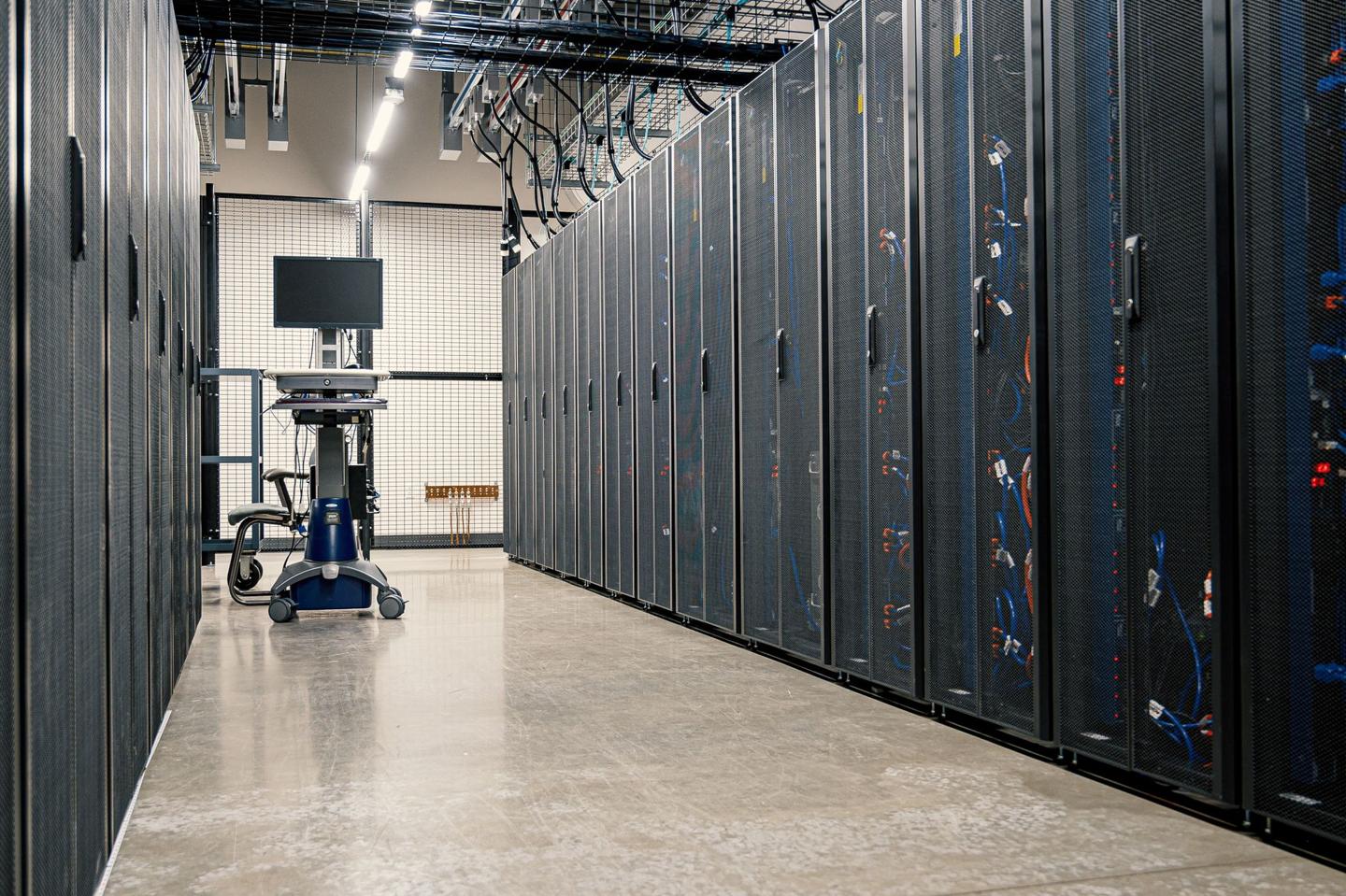 Salle de serveurs avec rangées de racks lumineux bleus et verts