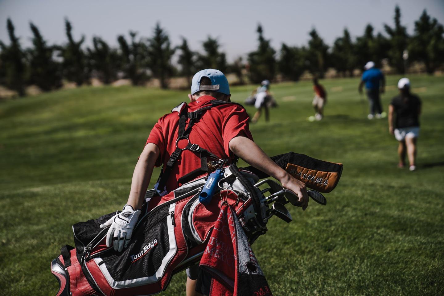 Joueur de golf en plein swing sur un parcours verdoyant au coucher du soleil