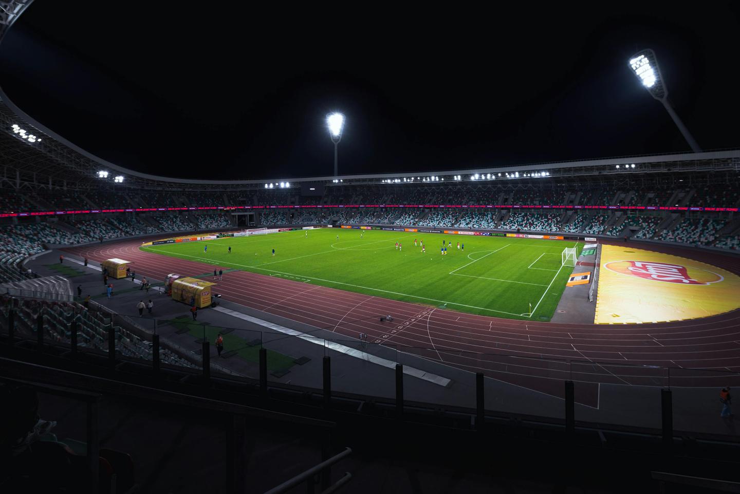 Stade de football illuminé en soirée pendant un match
