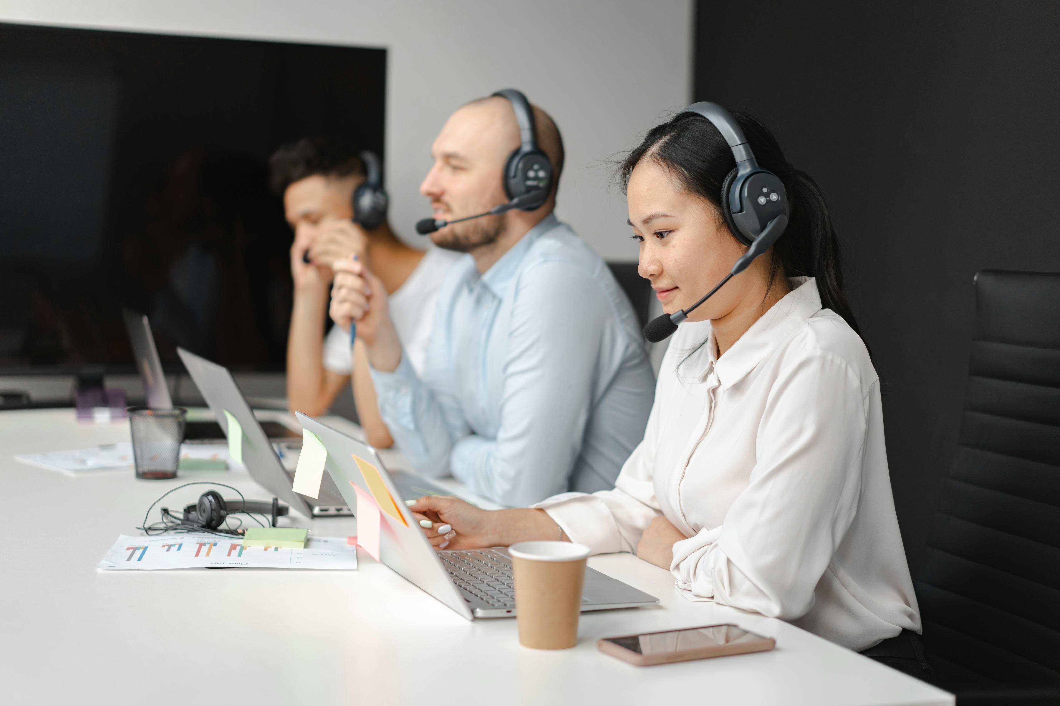 Équipe travaillant dans un centre d'appel moderne avec casques